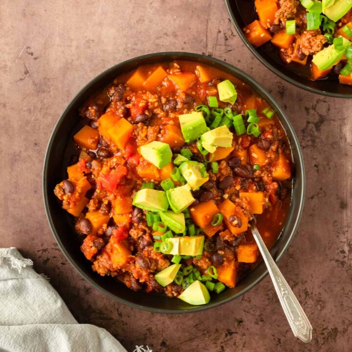 This butternut squash chili is a hearty and healthy comfort food recipe made with ground beef, butternut squash, beans and tomatoes for a delicious one-pot chili recipe.