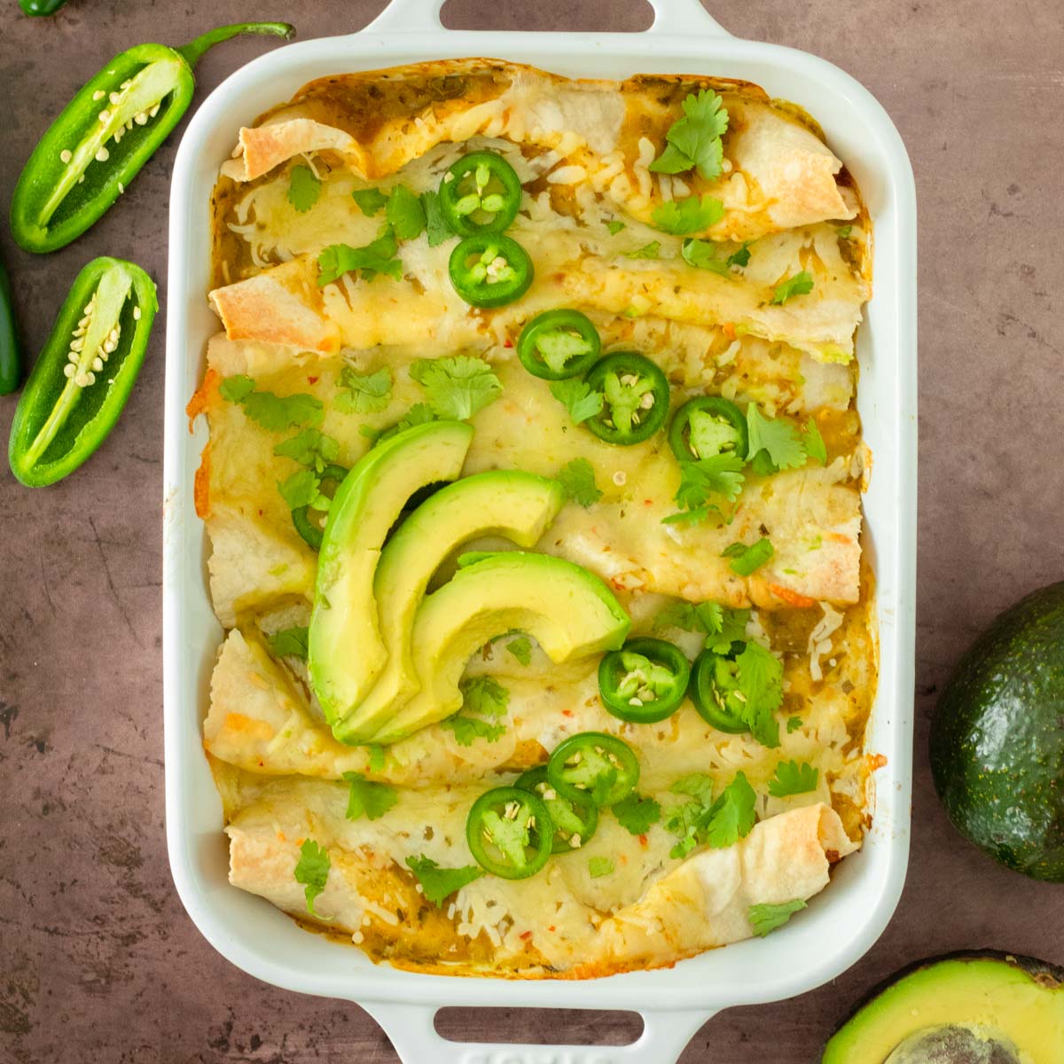 These salsa verde pork carnitas enchiladas are one of our most popular dinner recipes because this easy dinner recipe is the perfect quick, healthy and filling meal. These enchiladas are loaded with crockpot pork carnitas and cheese then baked in delicious sauce for the perfect comfort food any time of year.