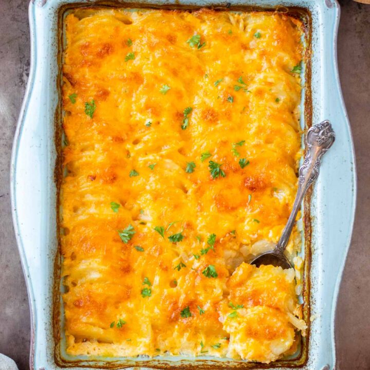 These cheesy scalloped potatoes are a classic side dish recipe made with thinly sliced potatoes cooked in a thick and creamy cheese sauce. We love serving this side dish for a holiday meal, like Easter dinner and also as a side for cookouts during the summer.