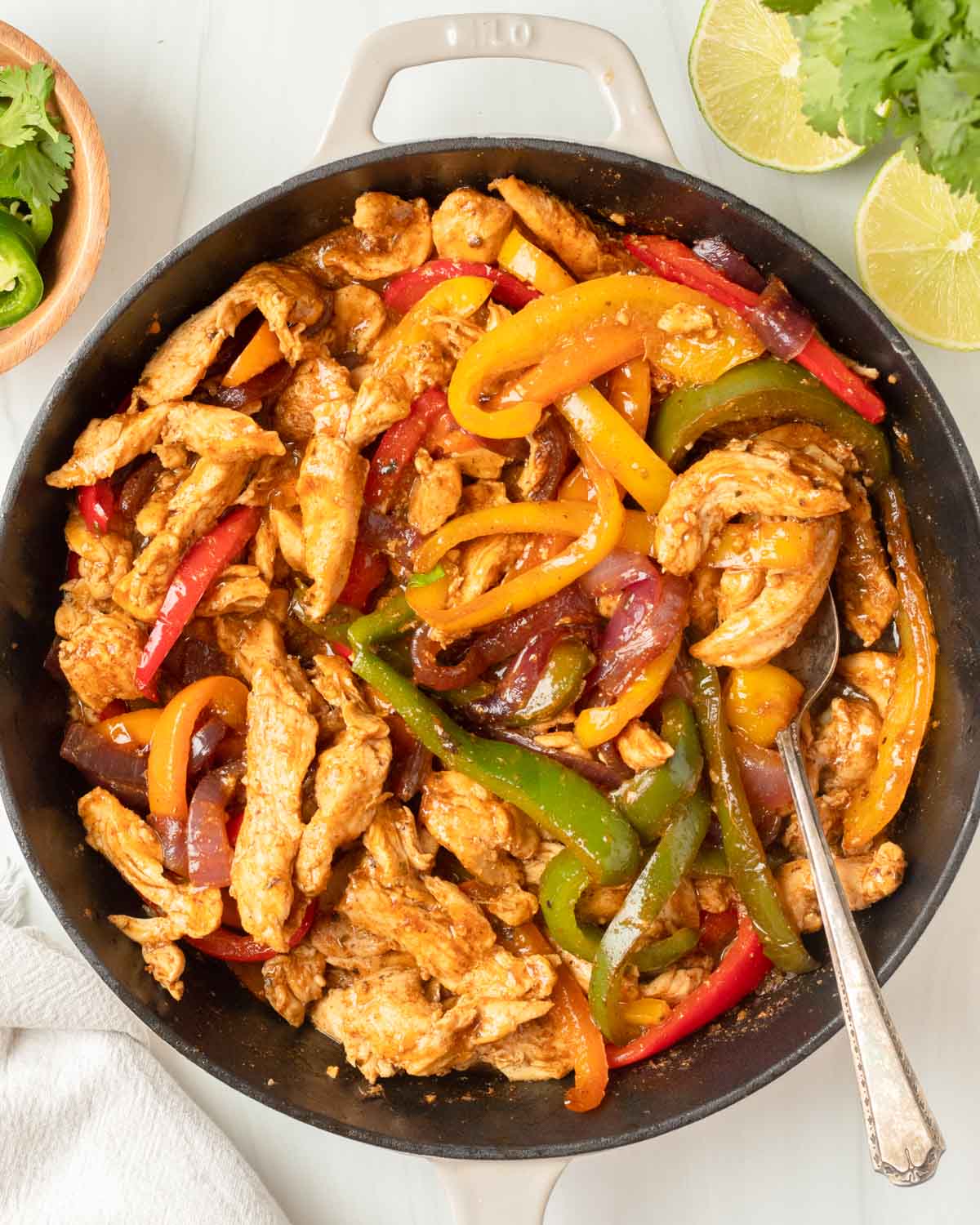 These chicken fajitas are a one-pan dinner made with chicken and vegetables cooked in a homemade fajita sauce and served in a tortilla and your favorite fajita toppings.
