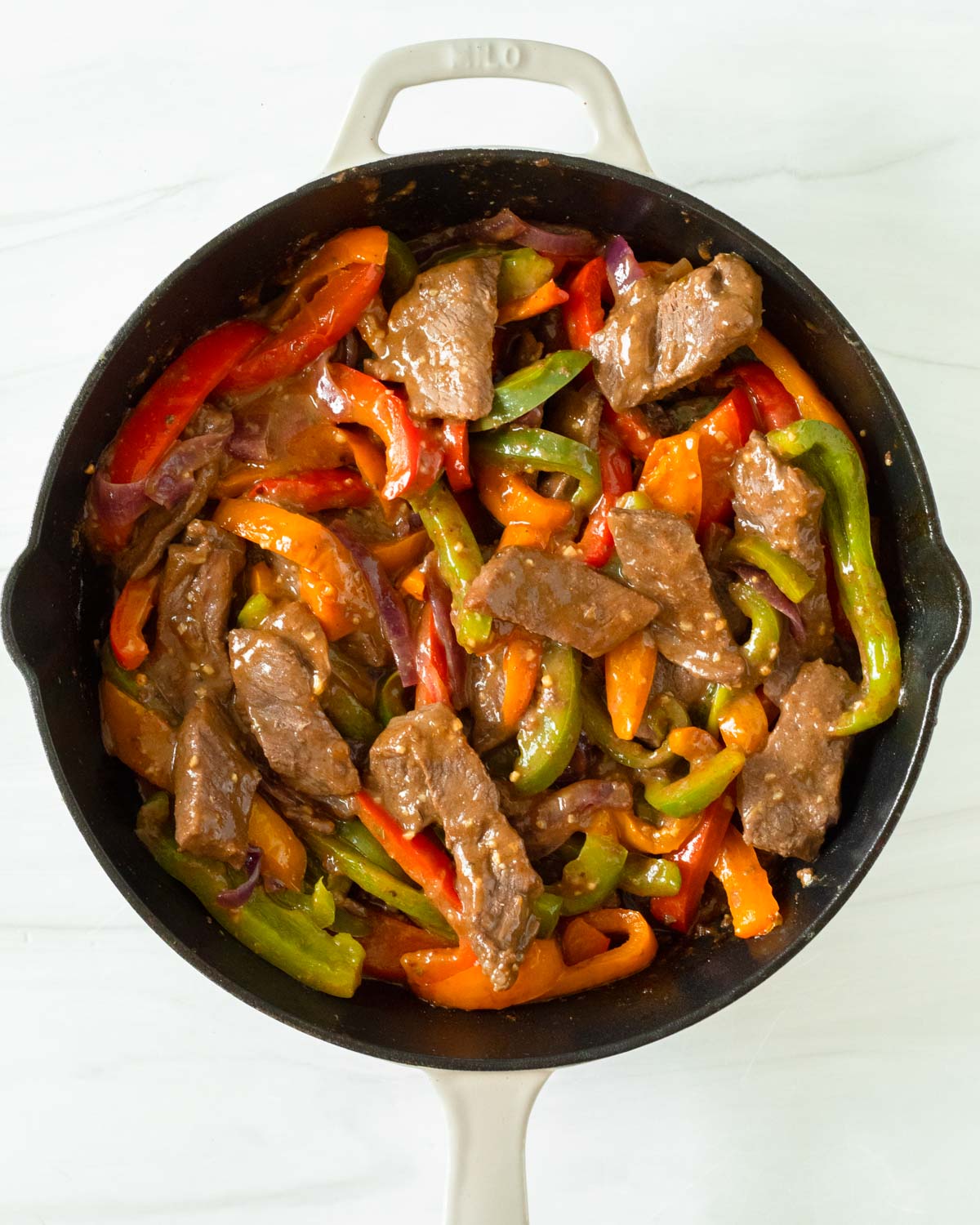 Step 6. Add the cooked peppers and onion back into the skillet