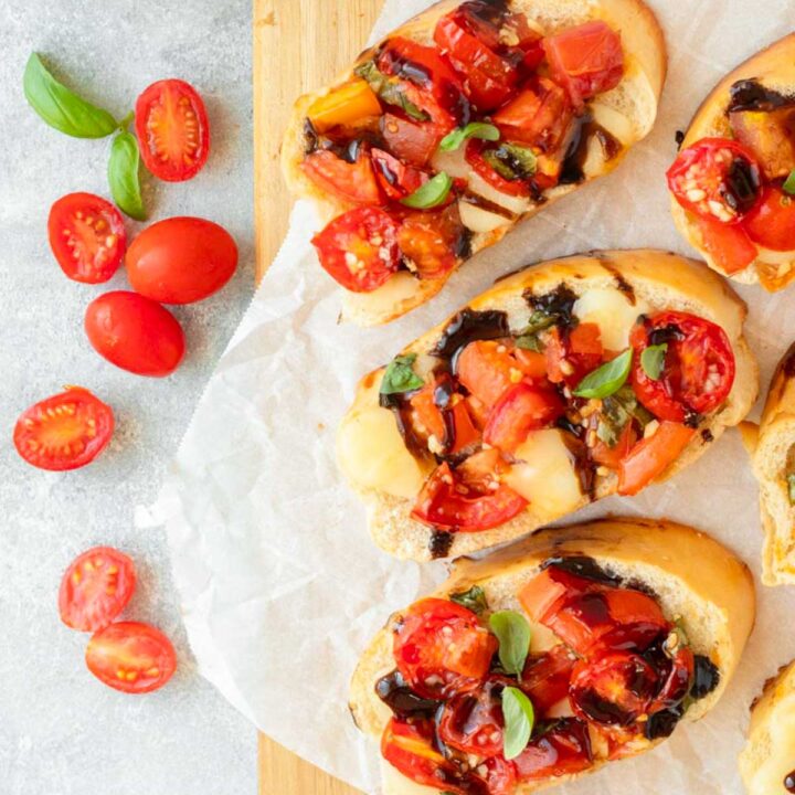 This baked bruschetta is an easy appetizer recipe made with bread topped with creamy mozzarella cheese and a fresh and flavorful mixture of tomatoes, basil and balsamic. This dish is perfect for a holiday appetizer, easy summer recipe and a great Fourth of July cookout recipe.