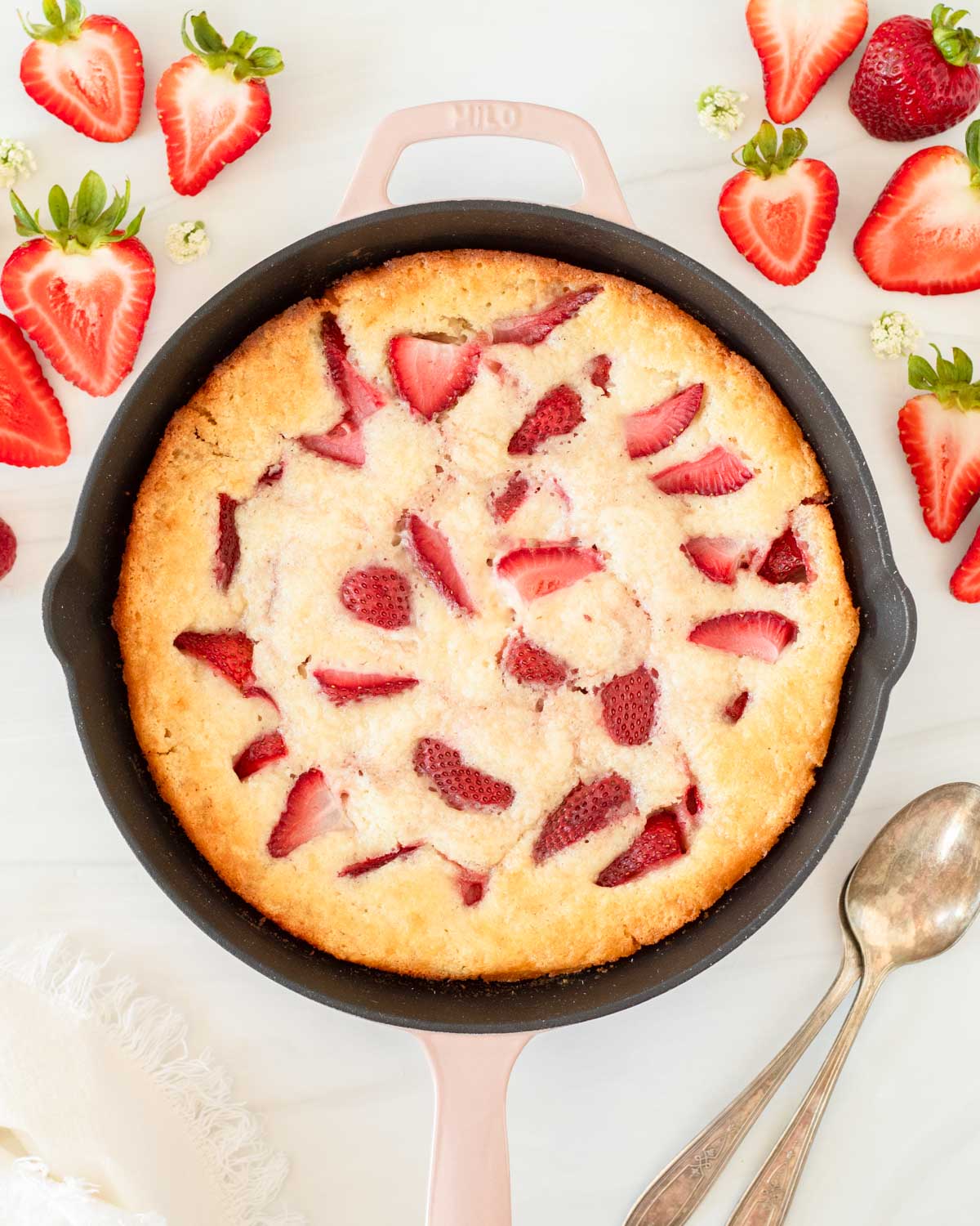 This strawberry cobbler is an easy summer dessert recipe that combines fresh-picked strawberries with a creamy batter to make a delicious one-skillet dessert.