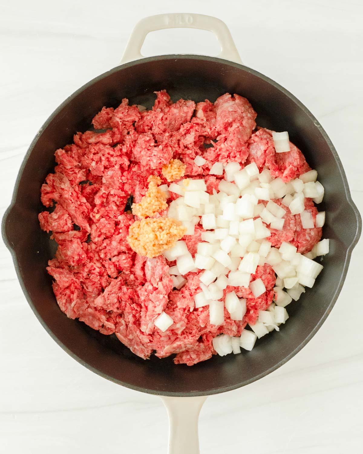 Step 1. Add the ground beef, onion and garlic to the skillet