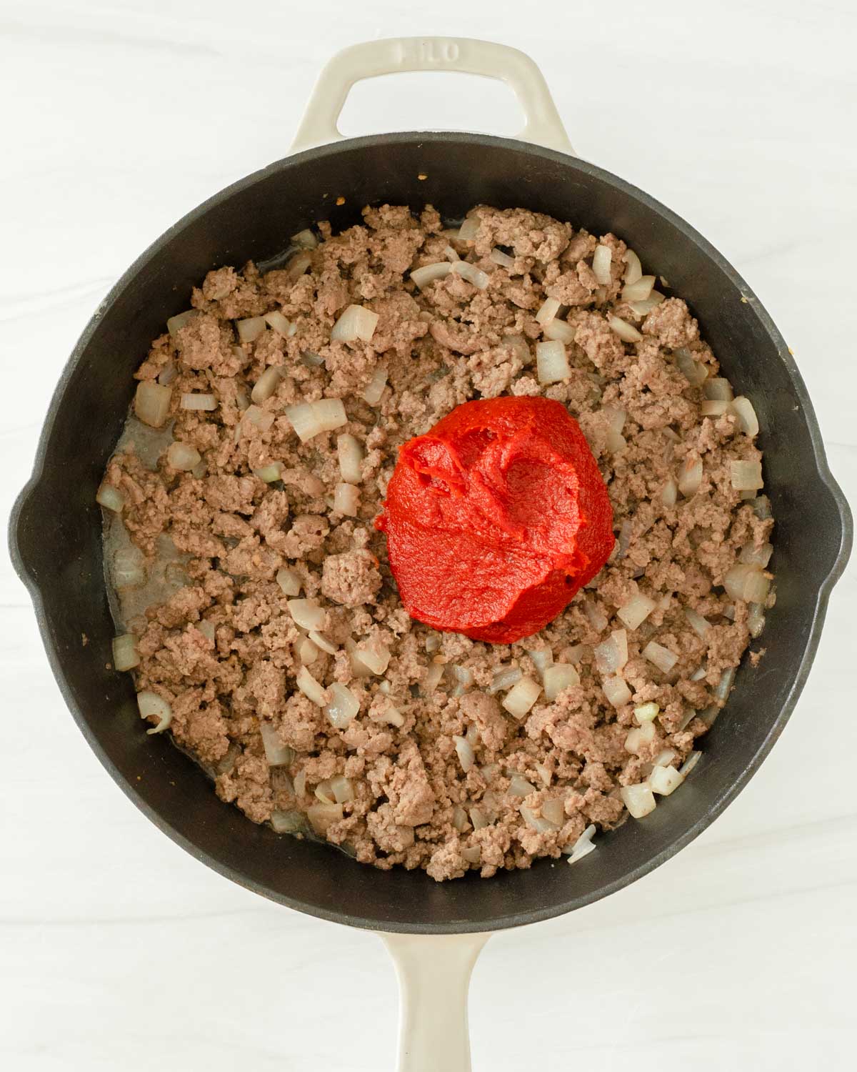 Step 3. Add the tomato paste to the skillet