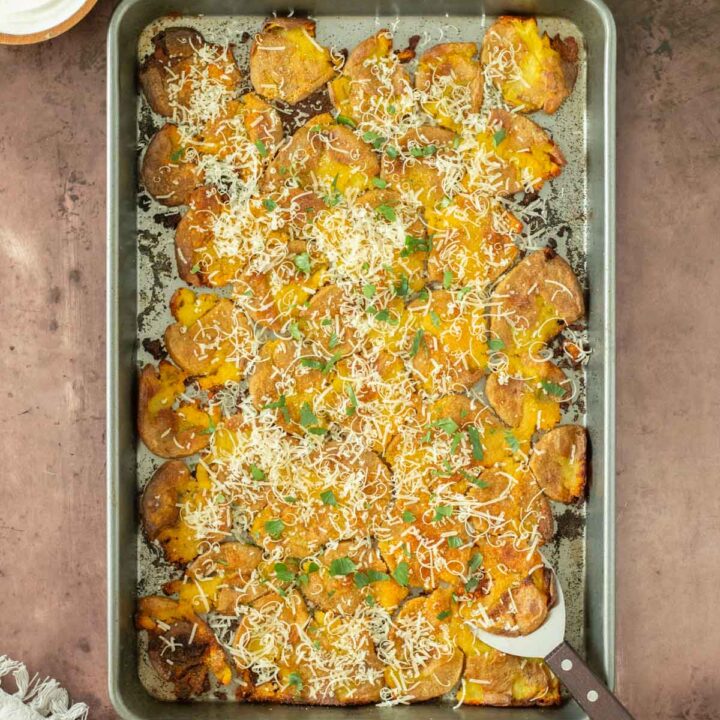 These garlic parmesan smashed potatoes are an easy and flavorful side dish perfect for a weeknight meal, holiday dinner, or as an appetizer. This smashed potato recipe makes crispy potatoes topped with simple spices for flavor and served with freshly grated parmesan cheese.