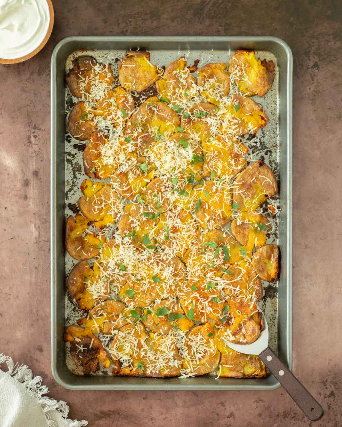 These garlic parmesan smashed potatoes are an easy and flavorful side dish perfect for a weeknight meal, holiday dinner, or as an appetizer. This smashed potato recipe makes crispy potatoes topped with simple spices for flavor and served with freshly grated parmesan cheese.