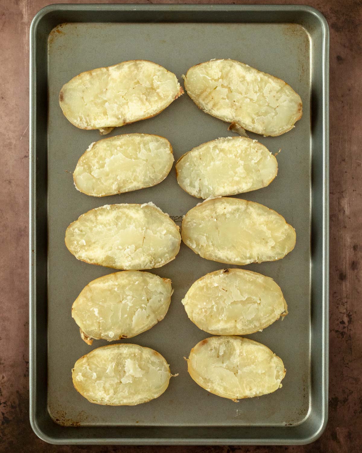 Step 2. Remove foil and cut each potato in half