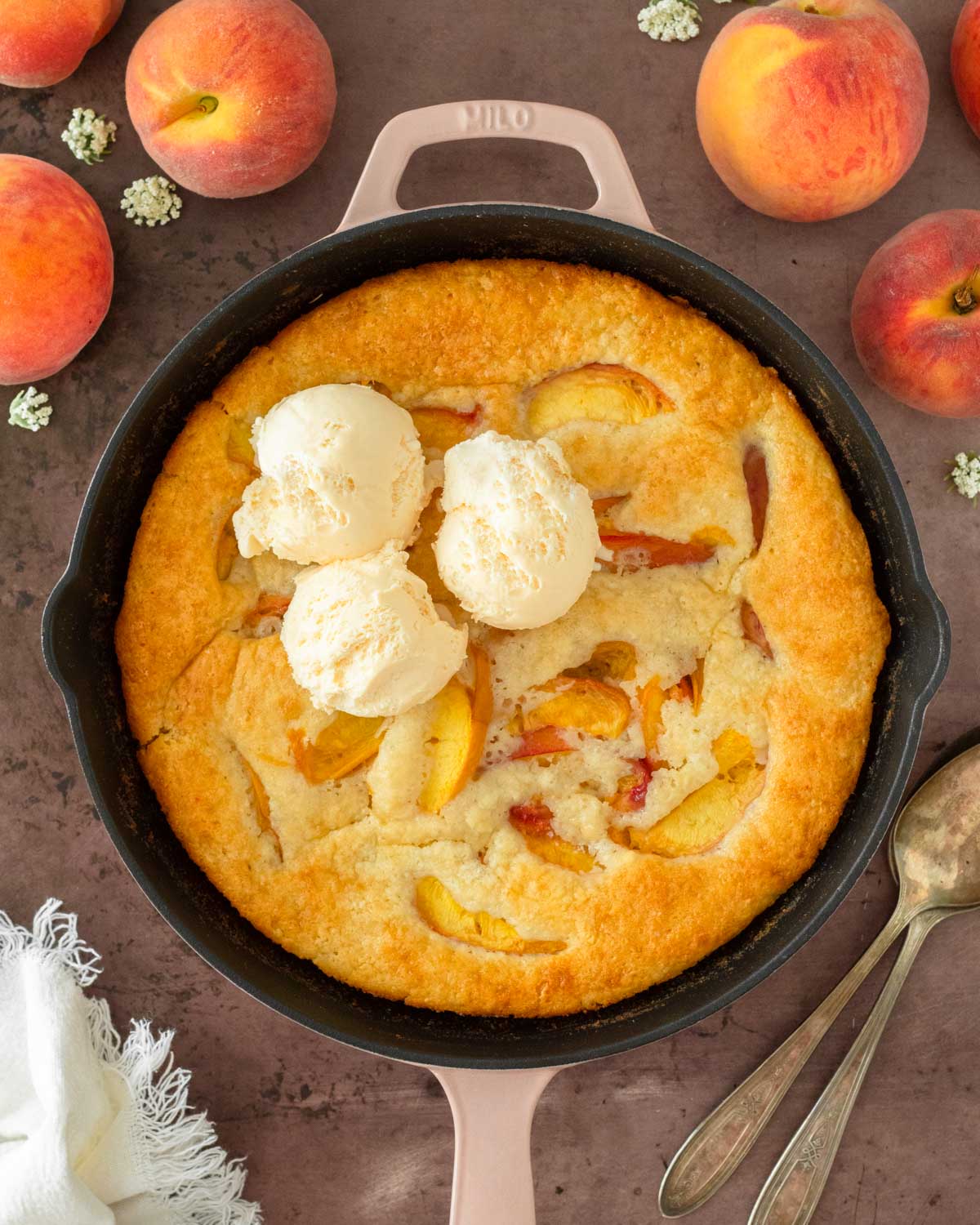 This peach cobbler is an easy summer dessert recipe that combines fresh-picked peaches with a creamy batter to make a delicious one-skillet dessert.