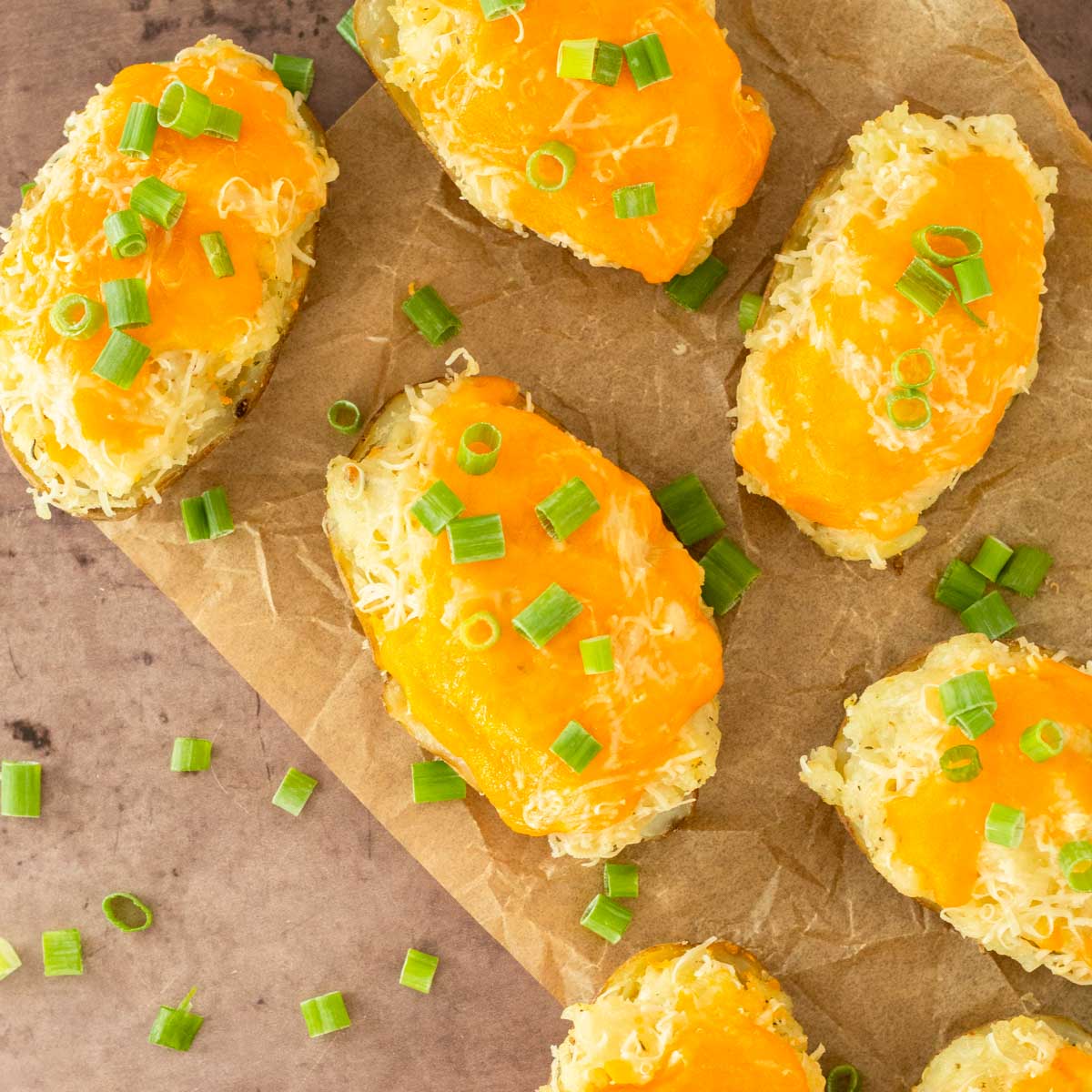 These twice baked potatoes are a classic summer side dish made with russet potatoes loaded with cheesy, flavorful mashed potatoes and topped with cheese. Serve this easy potato side at a summer cookout or Fourth of July party.