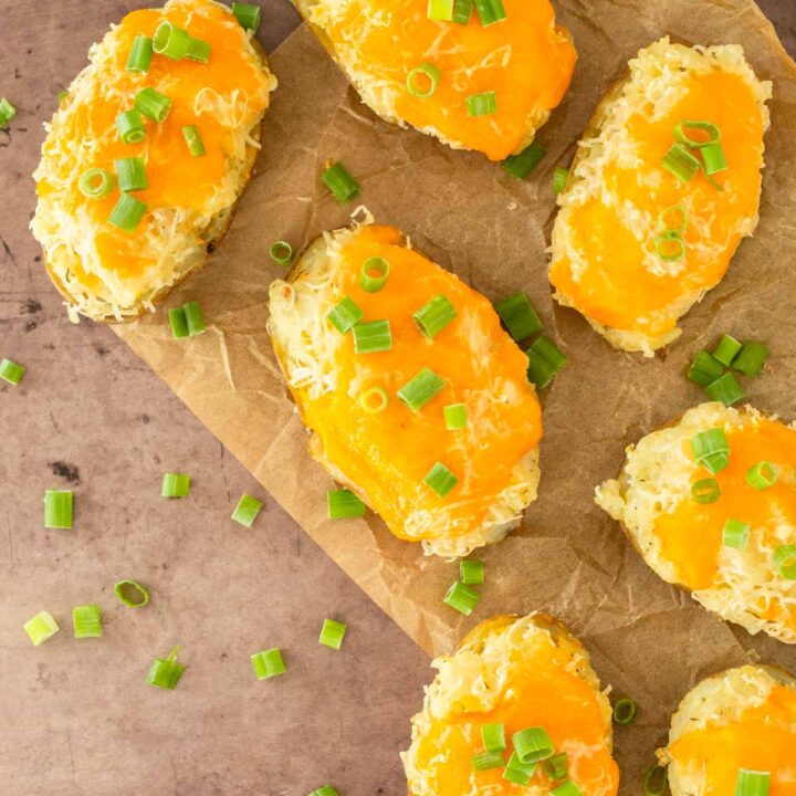 These twice baked potatoes are a classic summer side dish made with russet potatoes loaded with cheesy, flavorful mashed potatoes and topped with cheese. Serve this easy potato side at a summer cookout or Fourth of July party.
