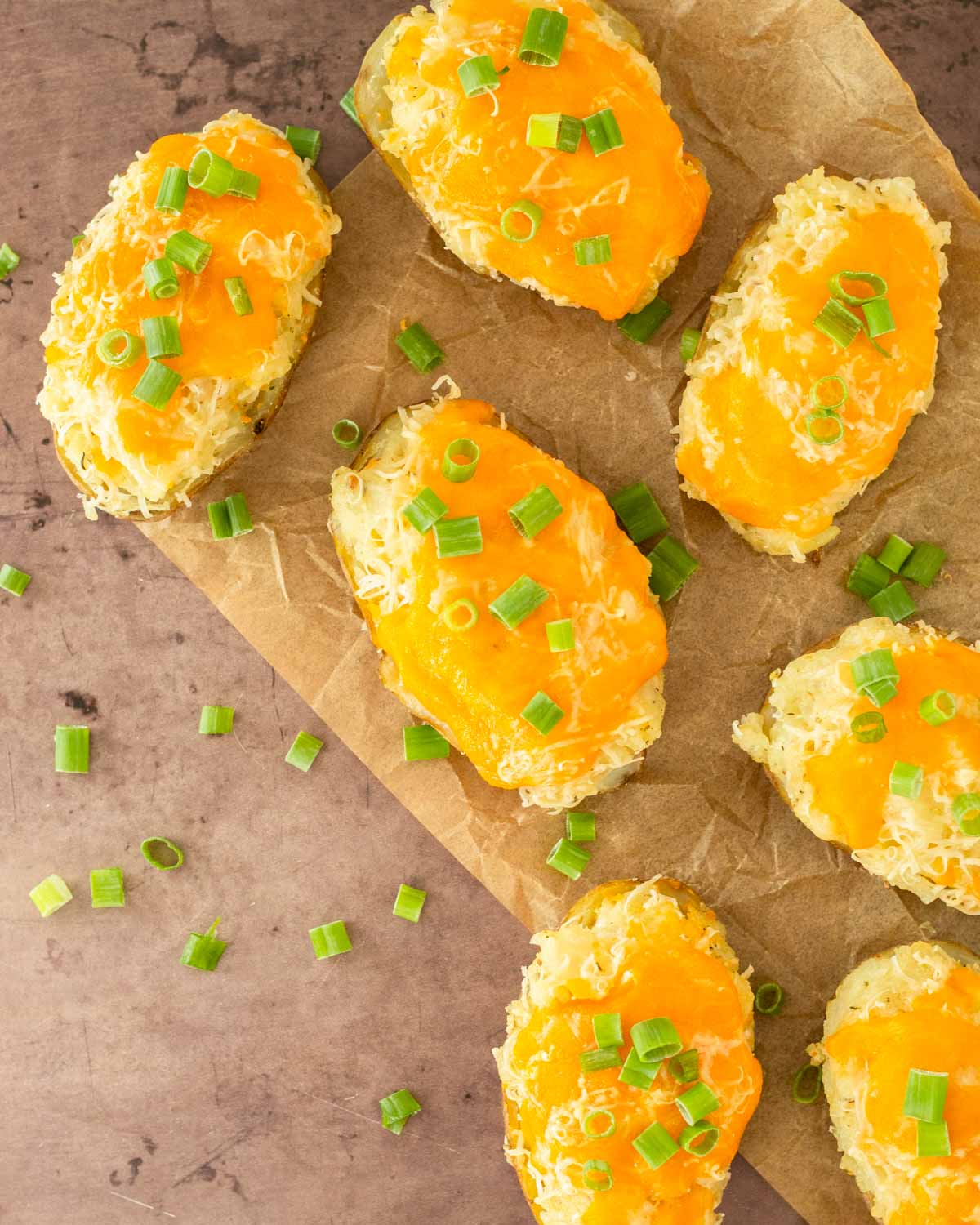 These twice baked potatoes are a classic summer side dish made with russet potatoes loaded with cheesy, flavorful mashed potatoes and topped with cheese. Serve this easy potato side at a summer cookout or Fourth of July party.