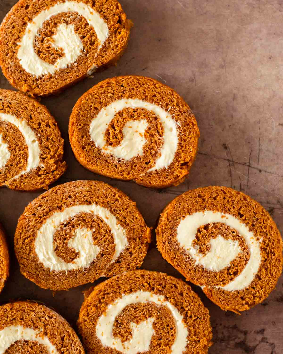 This pumpkin roll recipe is a simple pumpkin cake recipe filled with a homemade cream cheese frosting and rolled into a perfect spiral. This pumpkin roll cake with cream cheese filling is the perfect fall dessert and great for the holidays.