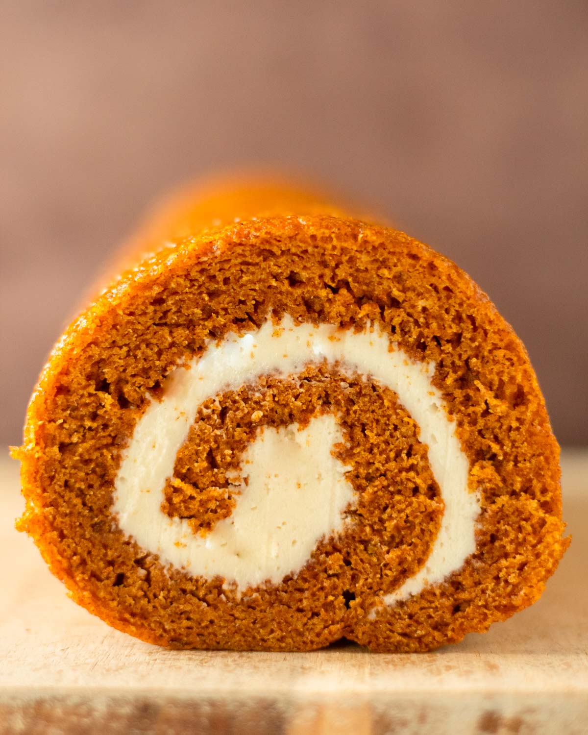 This pumpkin roll recipe is a simple pumpkin cake recipe filled with a homemade cream cheese frosting and rolled into a perfect spiral. This pumpkin roll cake with cream cheese filling is the perfect fall dessert and great for the holidays.