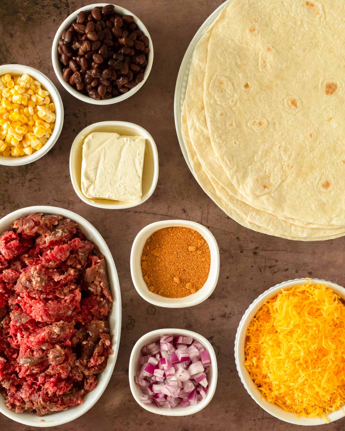 This sheet pan quesadilla is an easy dinner recipe perfect for a quick weeknight meal and also great for a fun appetizer. Made with tortillas loaded with a flavorful mixture of ground beef, vegetables, and cheese and baked until crispy, this sheet pan beef quesadilla is a crowd-pleaser.