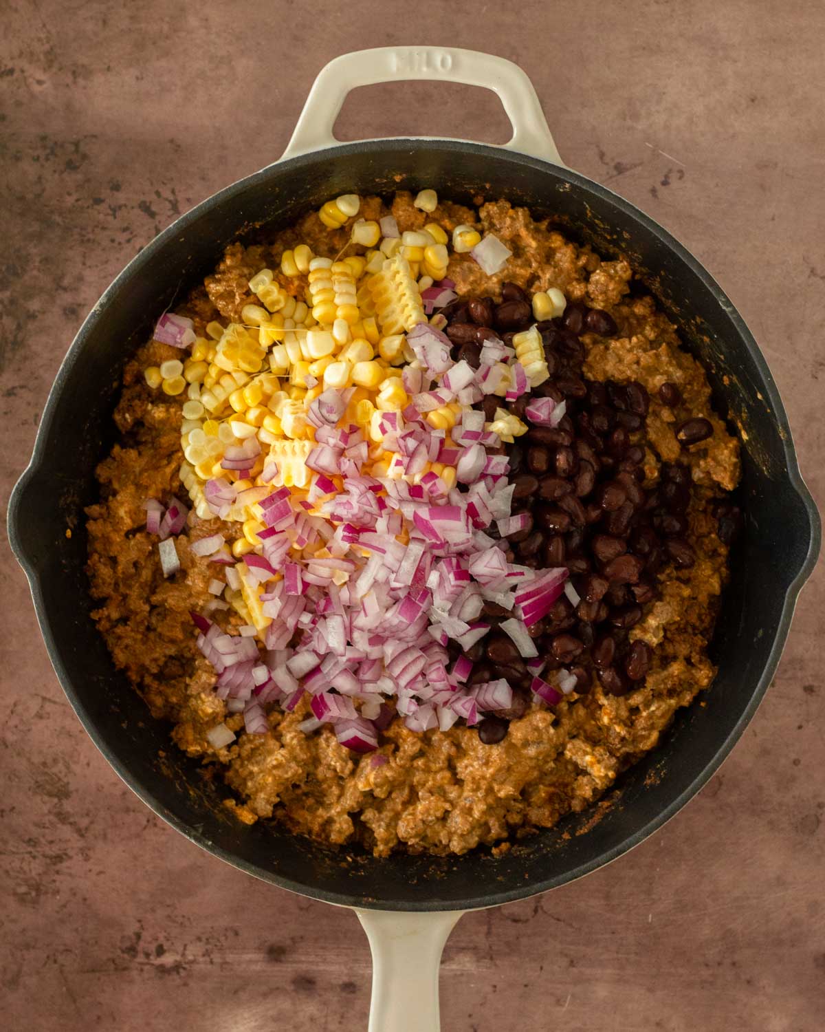 Step 3. Add the beans, corn and red onion to the skillet