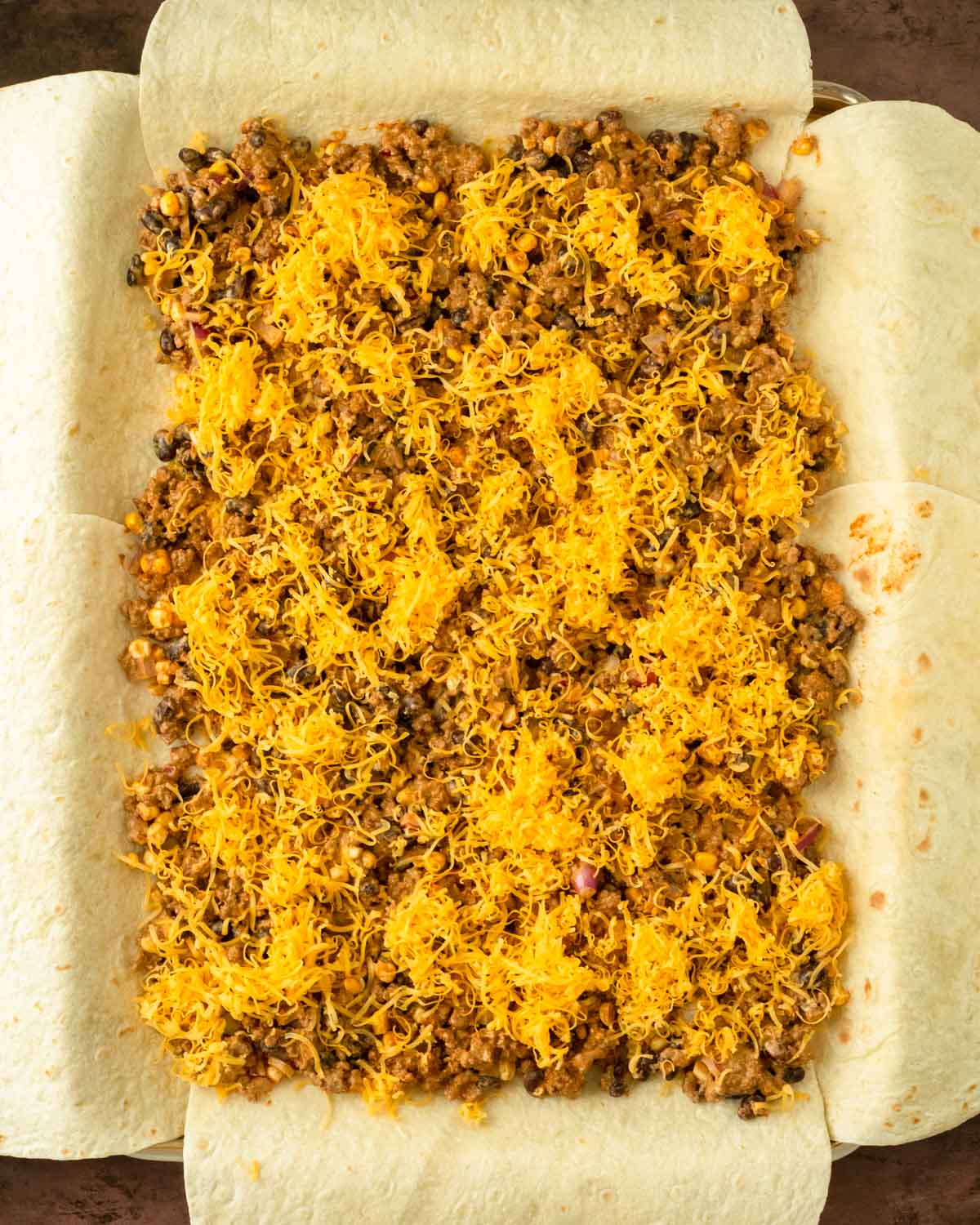 Step 6. Layer the cheese and taco meat on the tortillas