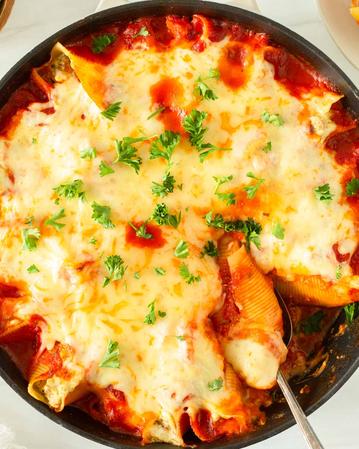 This recipe for lasagna stuffed shells is an easy one-skillet dinner recipe made with jumbo shells stuffed with classic lasagna ingredients and baked in the oven.