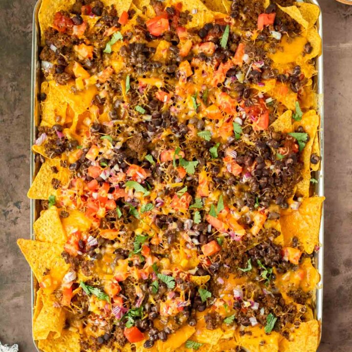 These sheet pan nachos are an easy appetizer recipe made with pantry-staple ingredients for a quick and flavorful crowd-pleaser dish. This recipe can be served for a game day appetizer but is also a great quick weeknight meal.