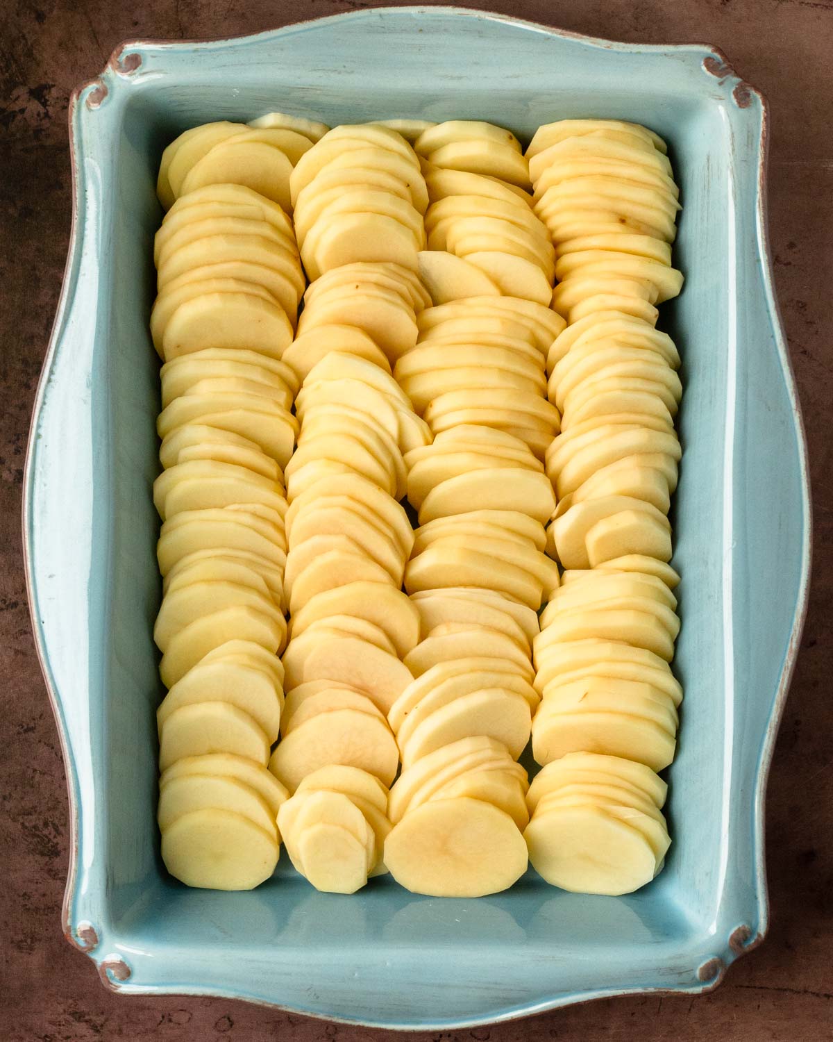Step 1. Peel and slice the potatoes then arrange in the baking pan
