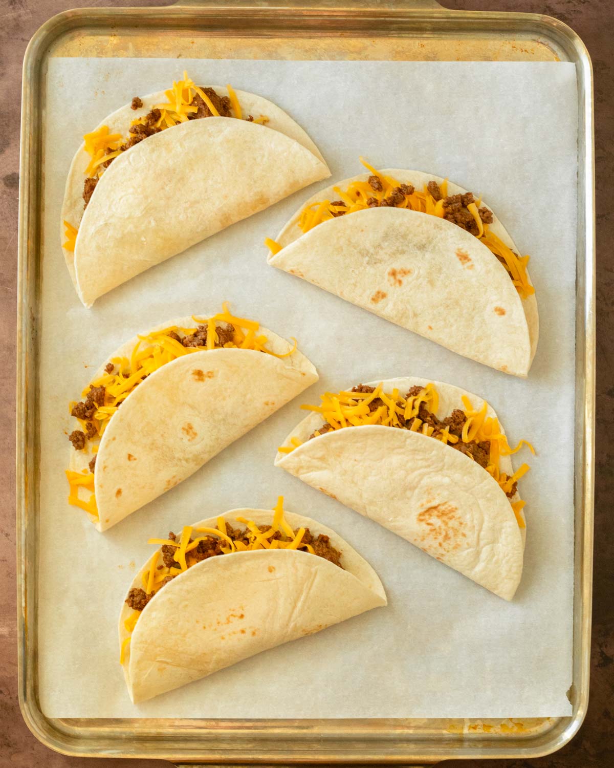 Step 1. Add the cheese and taco meat to the shells and place on a sheet pan