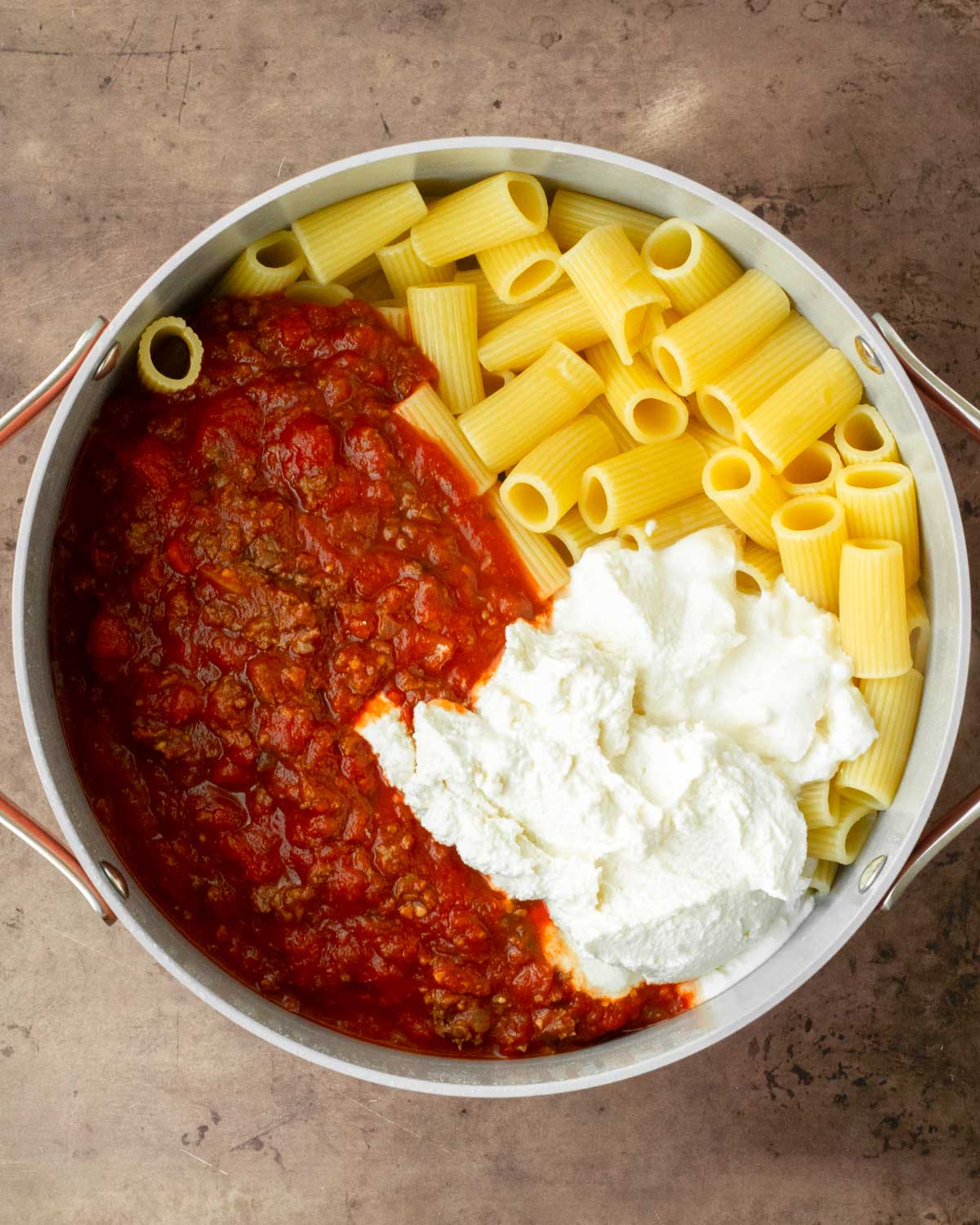 Step 1. Add the browned meat, sauce, ricotta and half of the mozzarella cheese to the pot with the boiled noodles