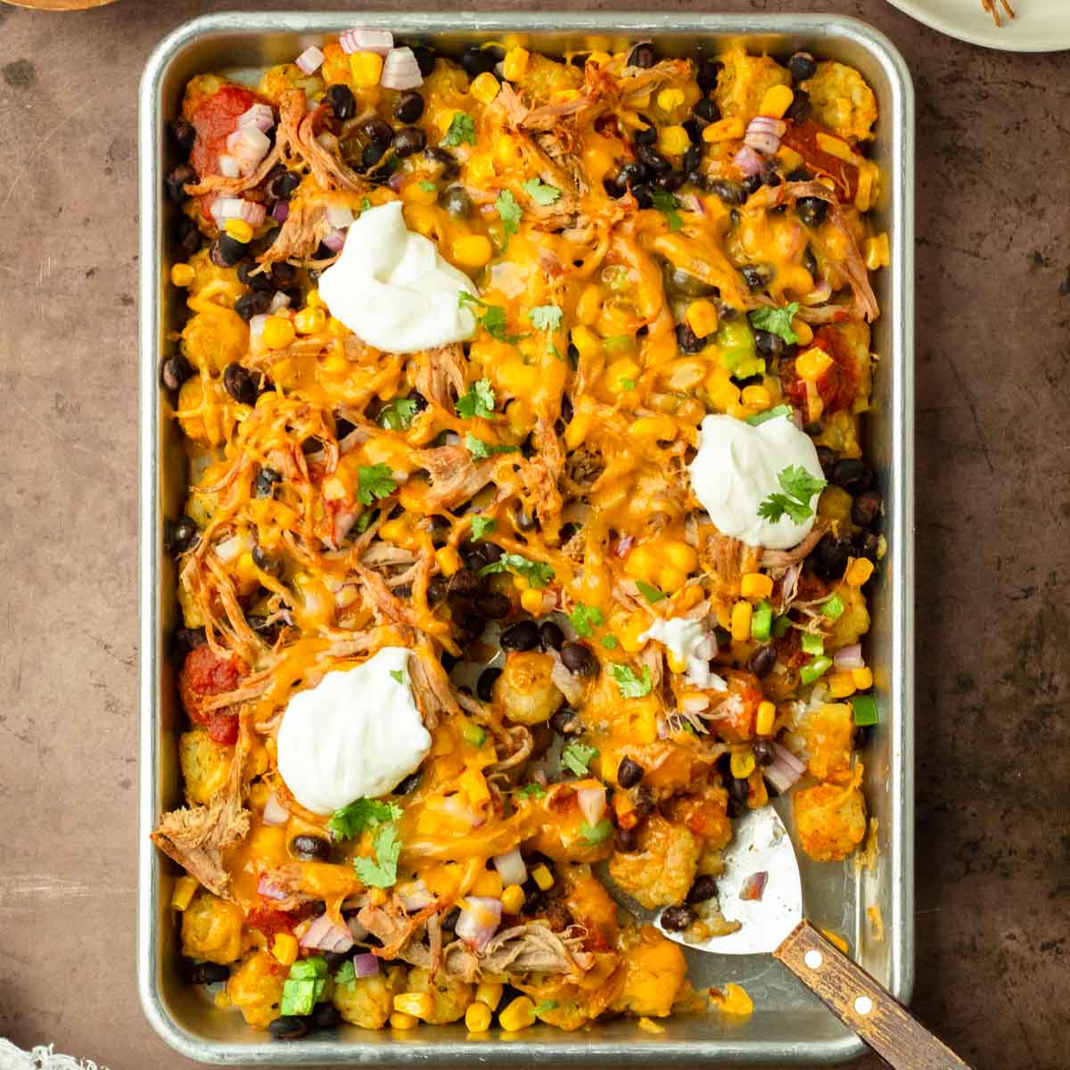 These bbq pulld pork totchos are made with crispy tater tots loaded with cheese, bbq pulled pork and other delicious toppings for a flavorful and crowd-pleaser dinner the entire family will love.