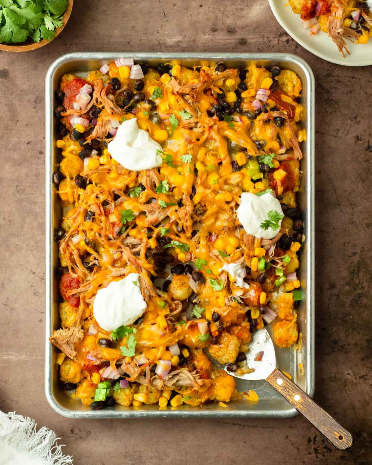 These bbq pulld pork totchos are made with crispy tater tots loaded with cheese, bbq pulled pork and other delicious toppings for a flavorful and crowd-pleaser dinner the entire family will love.