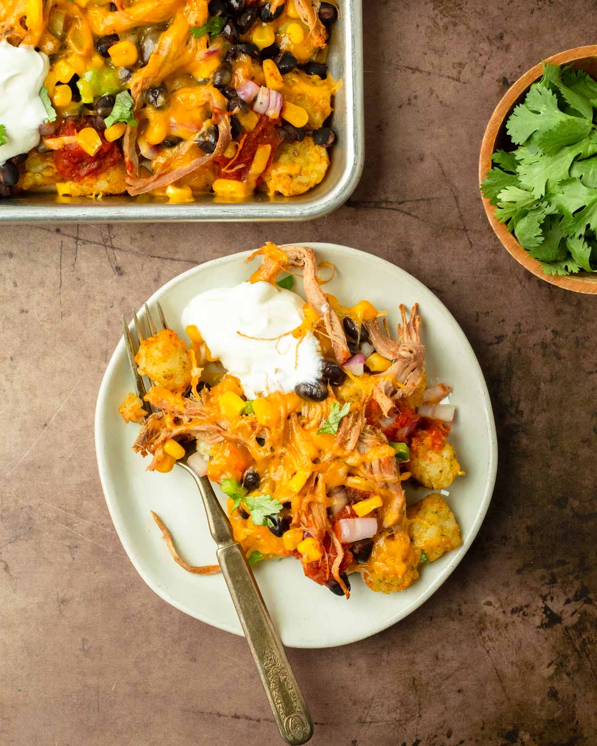 These bbq pulld pork totchos are made with crispy tater tots loaded with cheese, bbq pulled pork and other delicious toppings for a flavorful and crowd-pleaser dinner the entire family will love.
