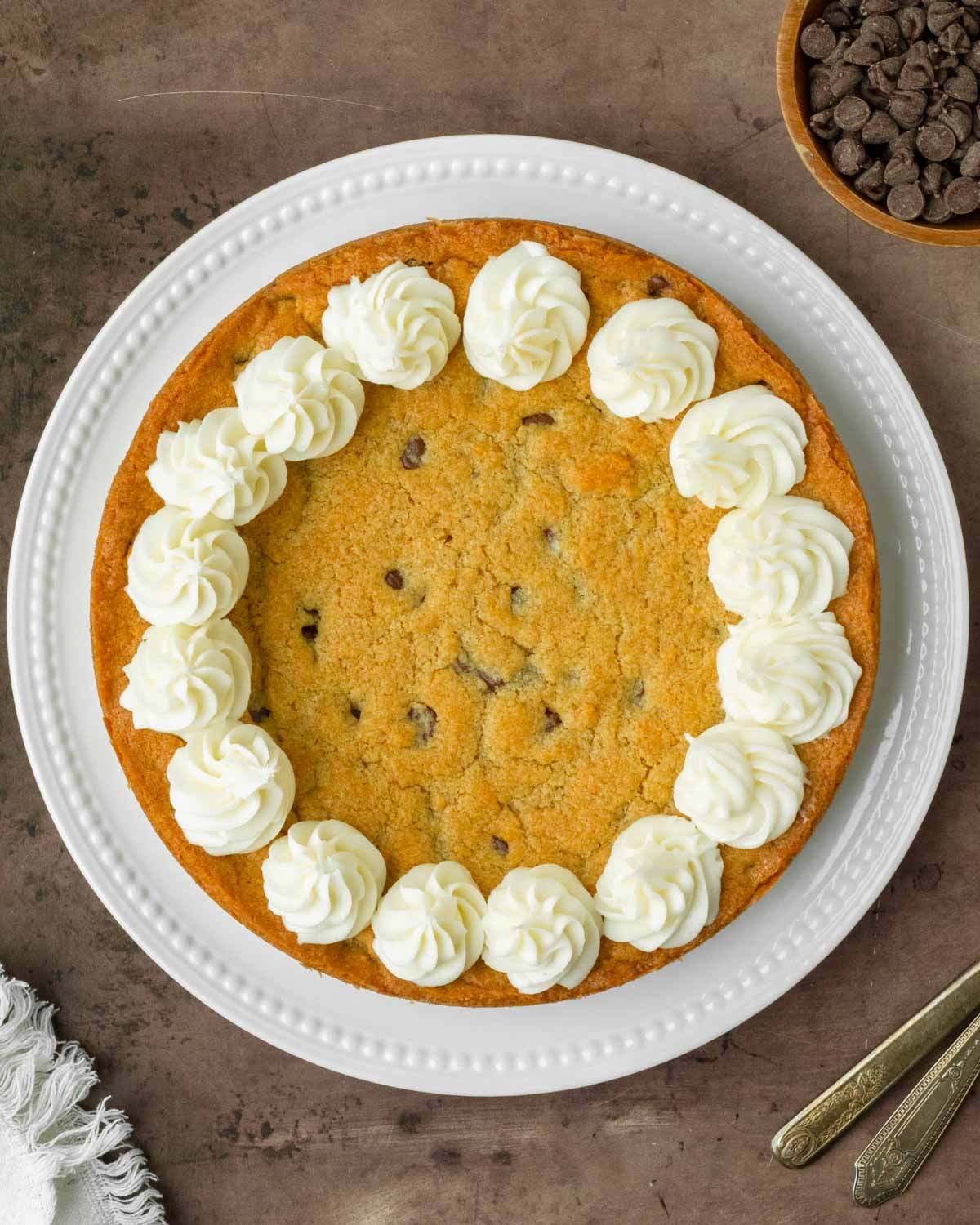 This homemade cookie cake is a thick and chewy chocolate chip cookie with a soft, chewy center and thick crisp edges perfect to serve to a crowd or enjoy as dessert with you family.